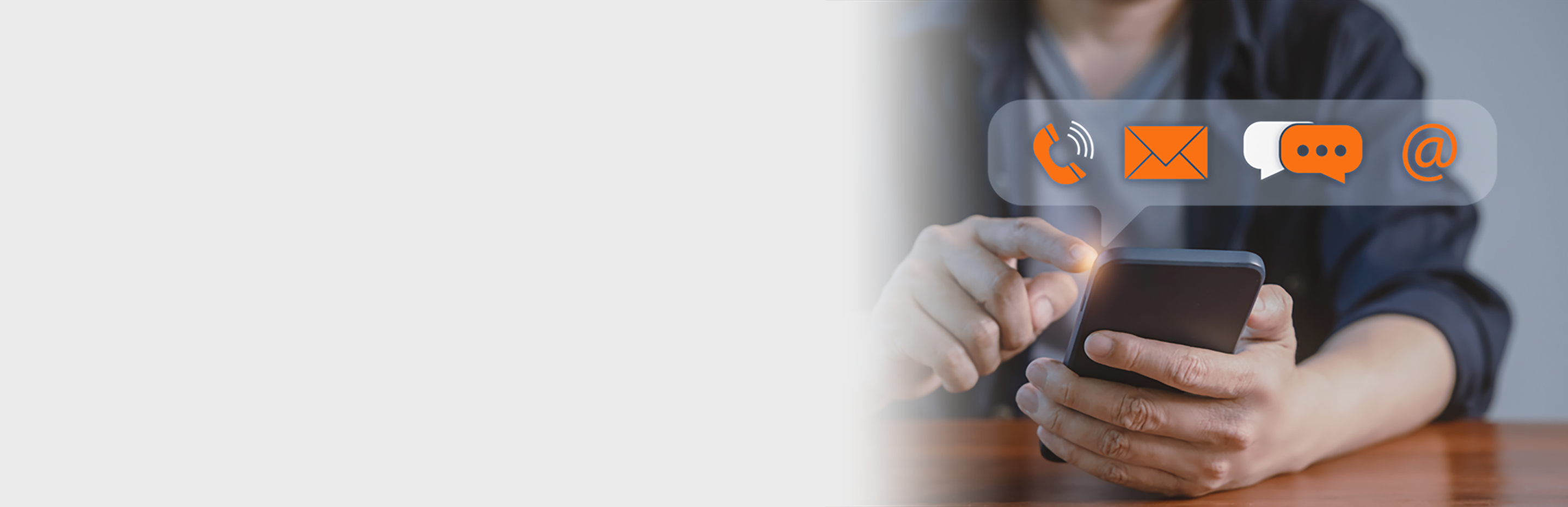 Businessman's hand is shown holding a mobile smartphone with mail, phone, and email icons displayed on the screen, Concept of contact us and customer support in the digital age